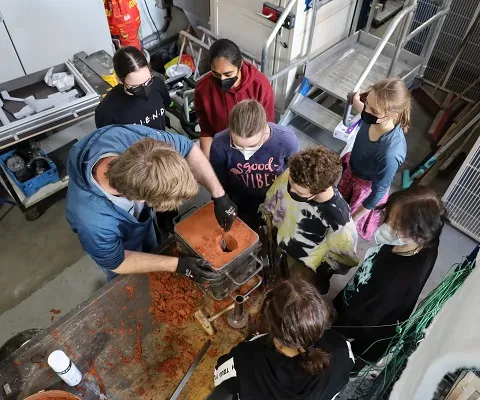 Girls sculpt a figure in sand at Girls Day at utg.
