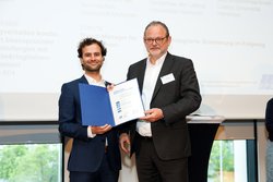 Lorenz Maier wird von K. Linnig die Urkunde zum EFB Projektpreis 2024 überreicht.