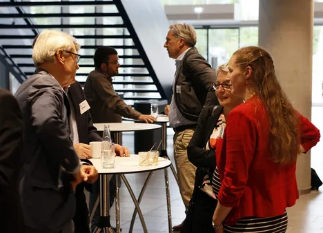 Drei Teilnehmende vertieft in die Diskussion am Industriekolloquium zum SPP2013