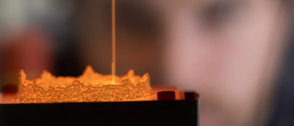 Ein Mitarbeiter sieht beim 3D-Metalldruck zu