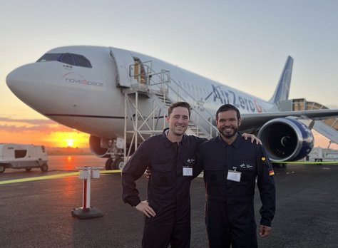 Constatin Bauer and a colleague from DLR stand in front of the AirZero aircraft in the evening sun. This aircraft is used to carry out parabolic flights with scientific experiments on board