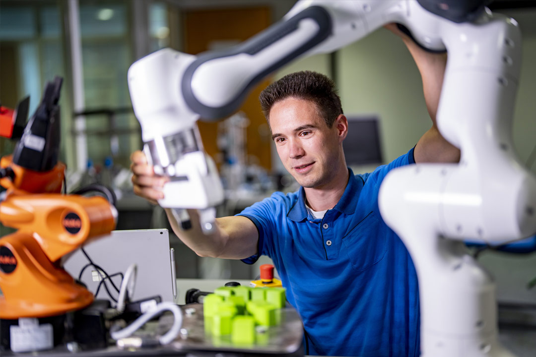 A man works with an industrial robot