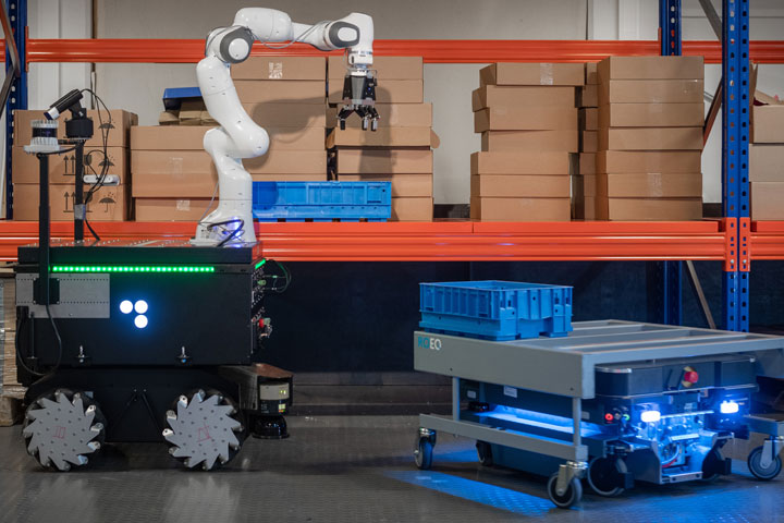 Zwei Roboter stehen vor einem Regal mit Paketen