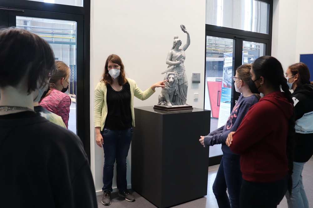 Die Mädchen schauen sich im Foyer des Fraunhofer IGCV die Bavaria Statue an und hören die Erklärungen von Patricia Erhard